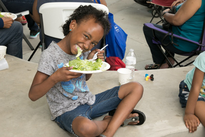 happy child eats salad from a plate