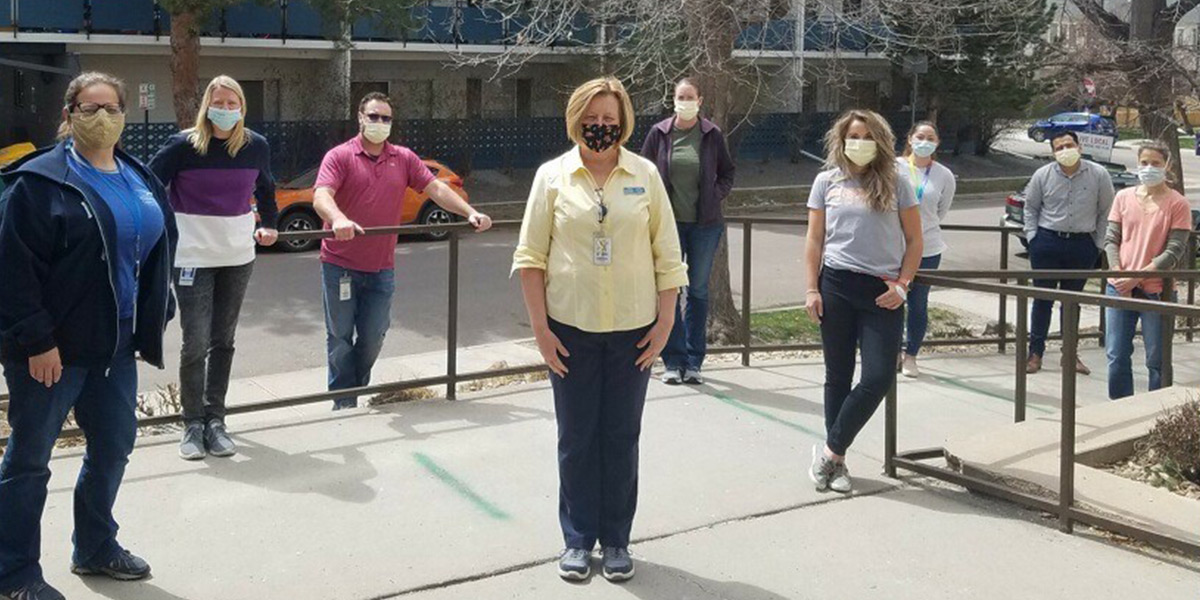 The pharmacy team stands outside of the Recovery Center in face masks.