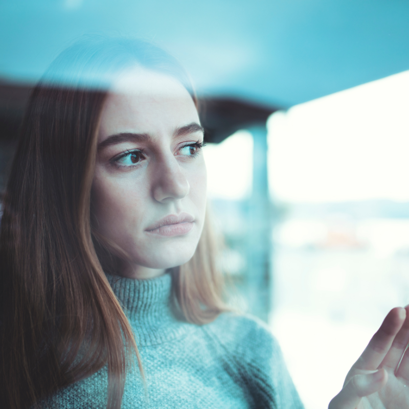2512_STOCK_Grief During Holidays_Woman looking out window