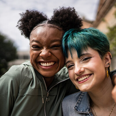 Portrait of friends embracing in the street