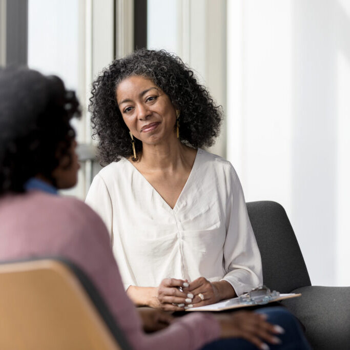 Mature counselor listens compassionately to their client