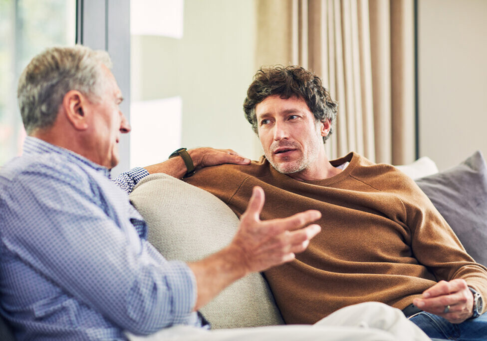Shot of a mature man and his elderly father sitting on the sofa at home and chatting